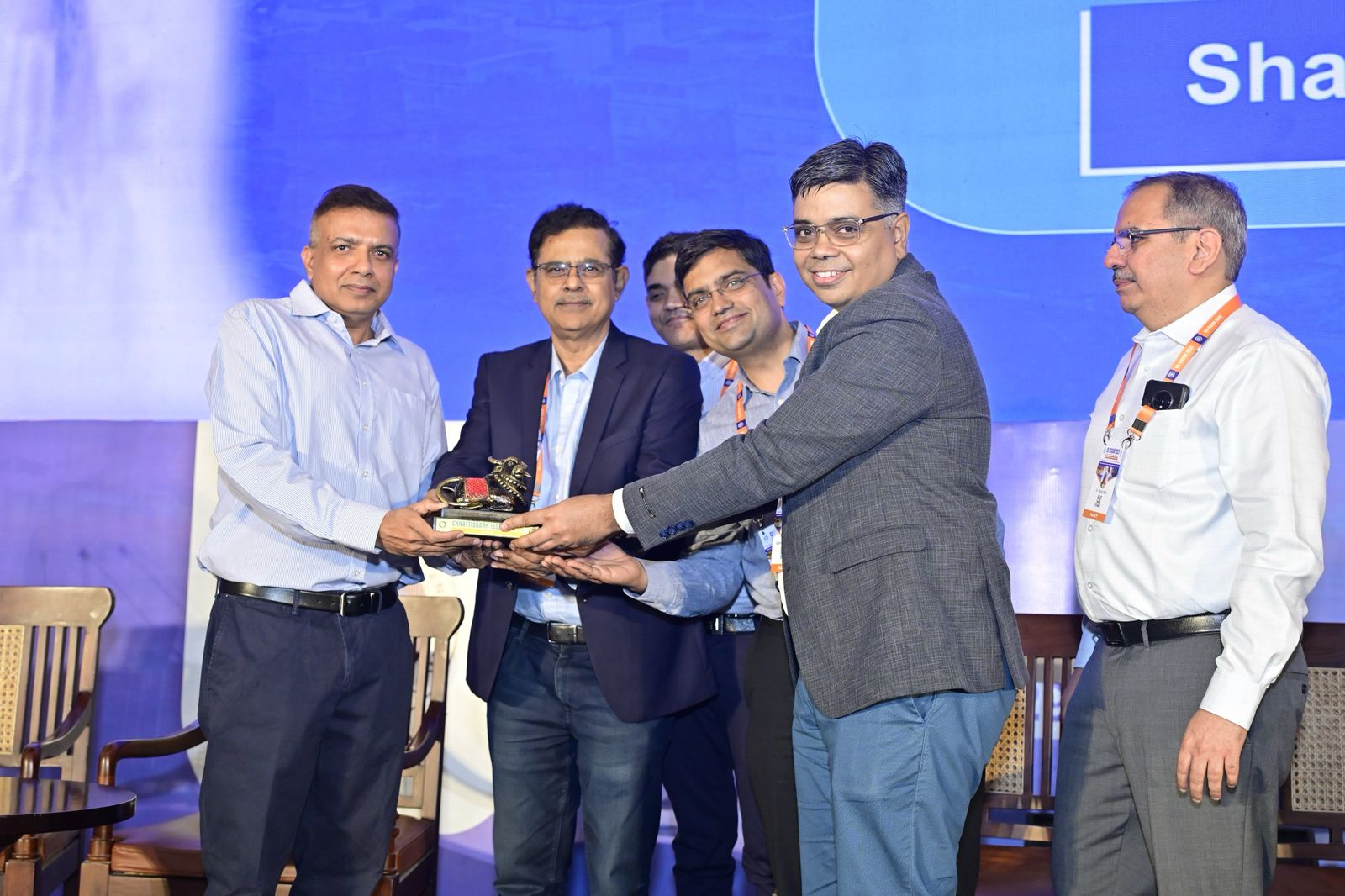 Achievement ceremony with four men in business attire